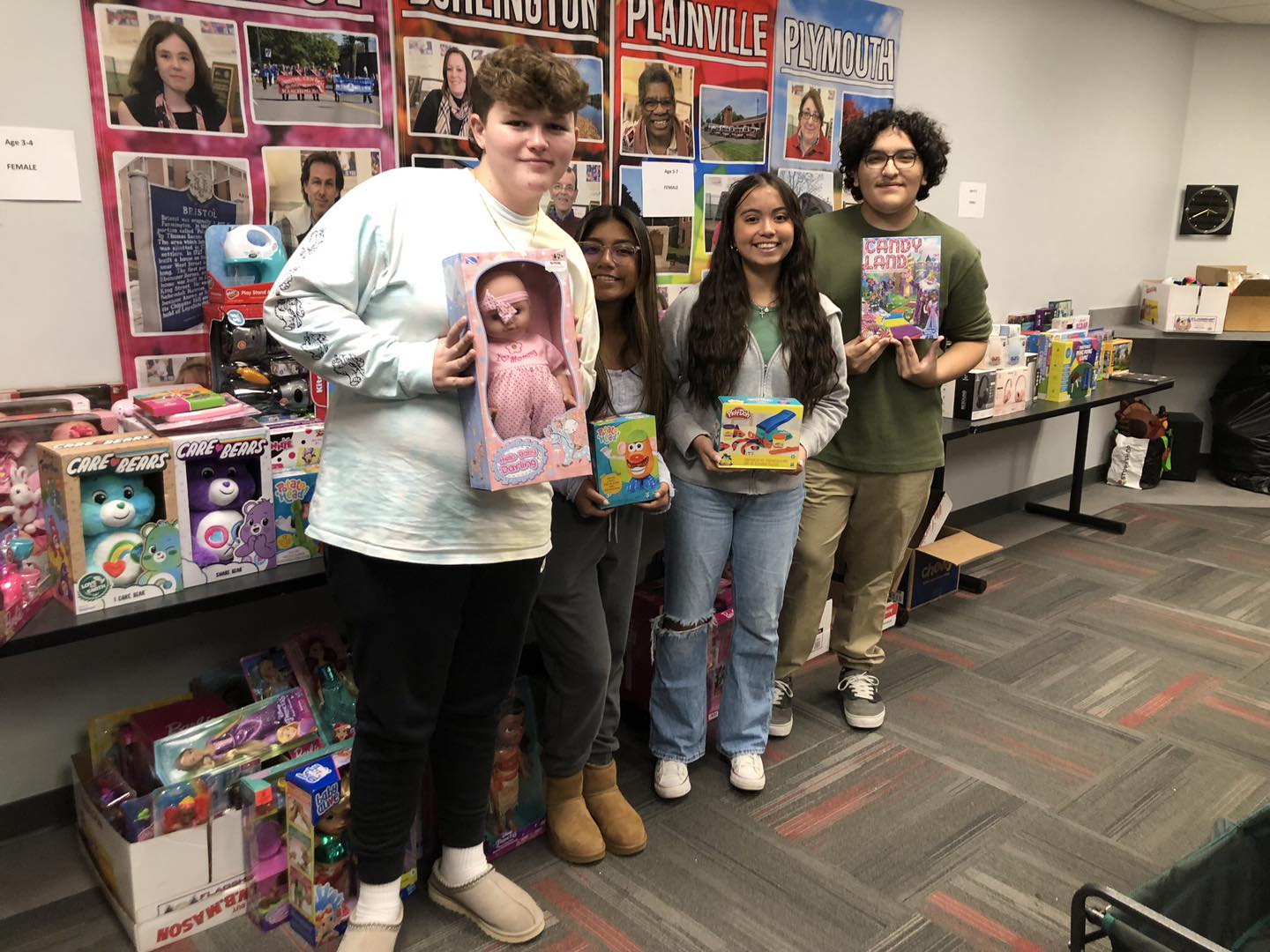 Four high school students dropping off toys